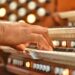 An unrecognizable diverse black musician plays the organ at a Sunday morning worship service